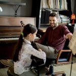 cute-little-girl-with-guitar-teacher-in-the-room-2025-02-21-19-31-32-utc